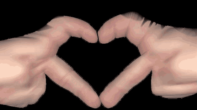 two hands make a heart shape with their fingers on a black background