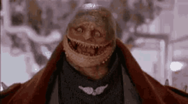 a close up of a monster with a scarf around his neck and a smiley face .