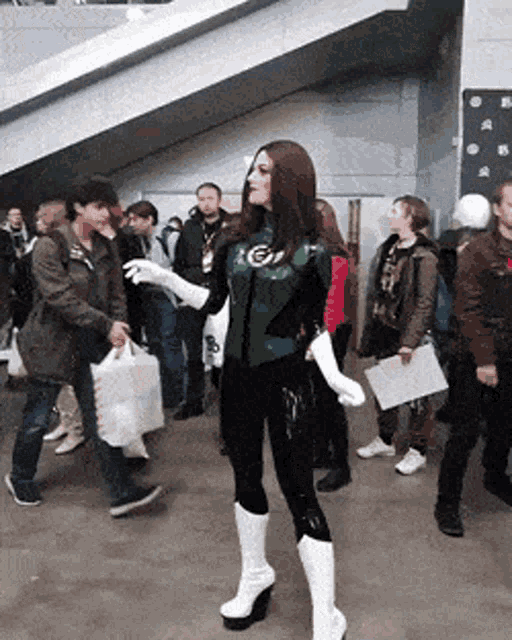 a woman in a green lantern costume is surrounded by people