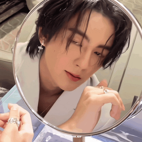 a close up of a person looking at themselves in a mirror with the words nu.gif below it