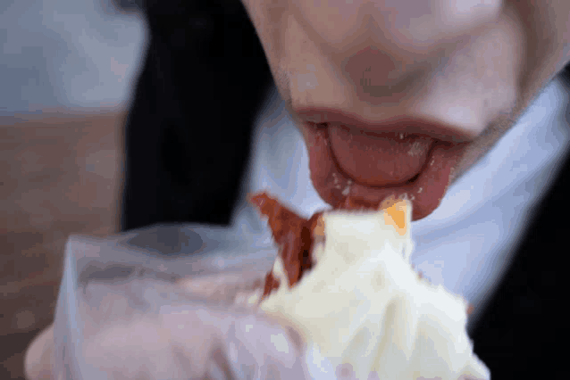 a person eating a piece of cake with their tongue sticking out