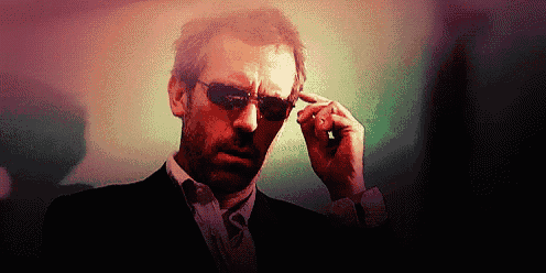 a man in a suit and tie wearing sunglasses