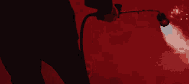a person is holding a torch with flames coming out of it in a dark room