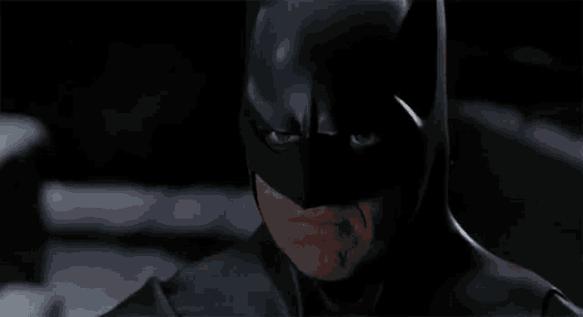 a close up of a person wearing a batman mask