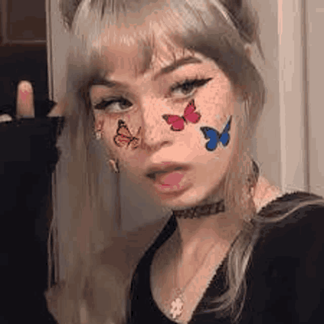 a girl with butterflies painted on her face is wearing a choker necklace .