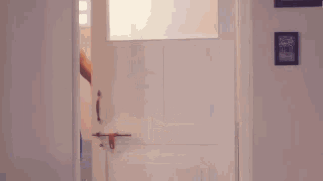 a shirtless man is opening a door in a bathroom .
