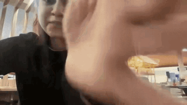 a close up of a person 's face with their hand visible