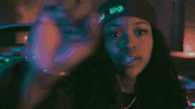 a woman wearing a black hat with the letter m on it is giving the middle finger