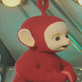 a red teddy bear with a white face and ears is standing in a room .