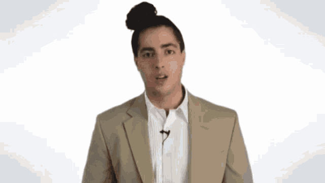a man in a tan suit has a microphone on his jacket
