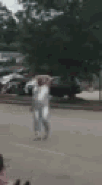 a blurry picture of a person walking down a street with trees in the background