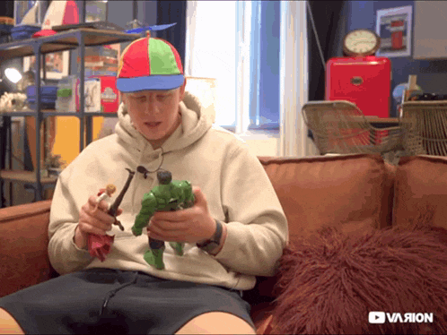 a man sitting on a couch holding a toy and a youtube logo