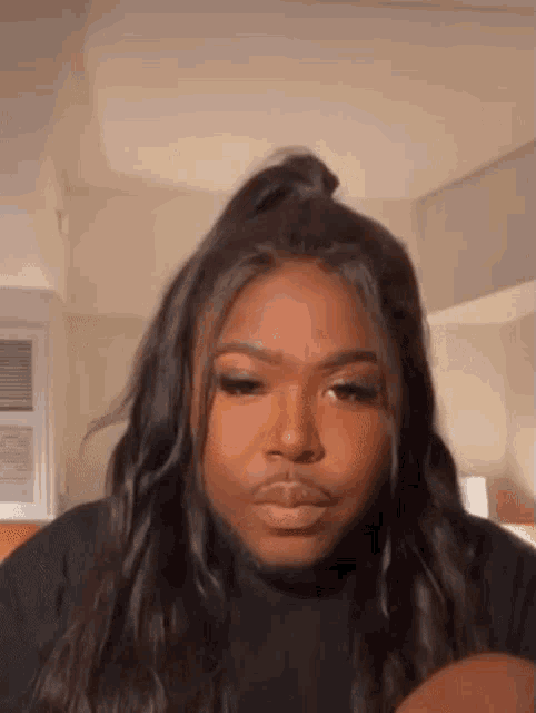 a woman with long hair and a ponytail is making a funny face .