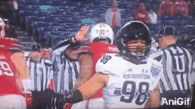 a football player wearing number 98 is being hugged by another player