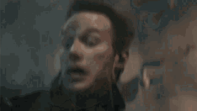 a close up of a man 's face in a dark room with a gun .