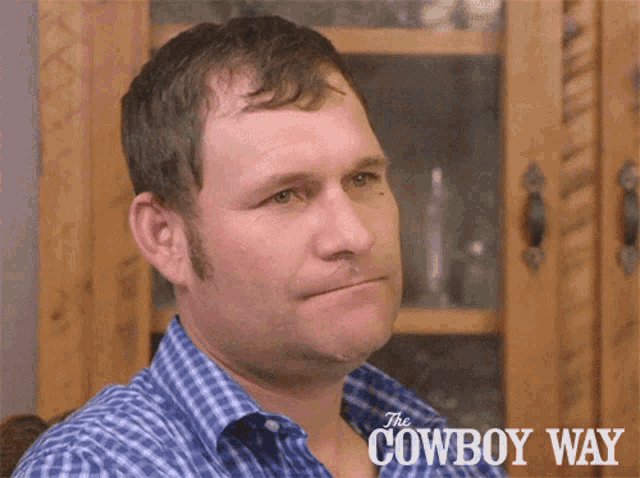 a man in a blue plaid shirt with the words the cowboy way on the bottom