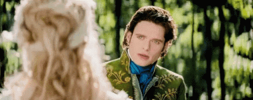a man in a green suit is standing next to a woman in a white dress in a forest .