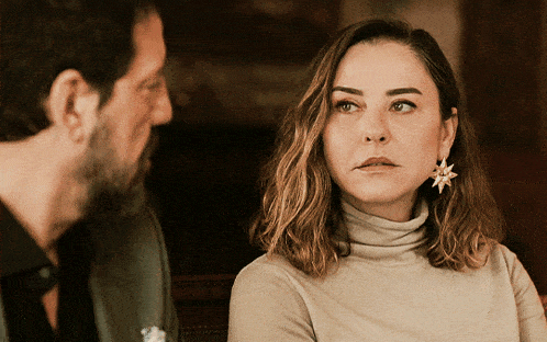 a man and a woman are looking at each other with the woman wearing a star earring