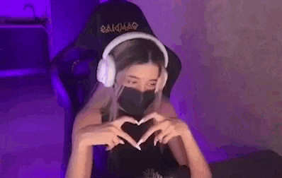 a woman wearing headphones and a mask is sitting in a chair in a room .