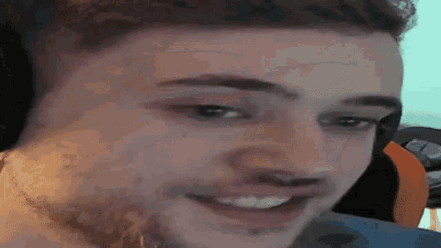 a man with a beard is smiling and looking at the camera while wearing headphones .