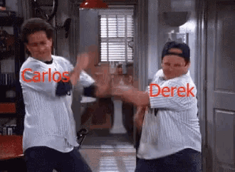 carlos and derek are standing next to each other in a room