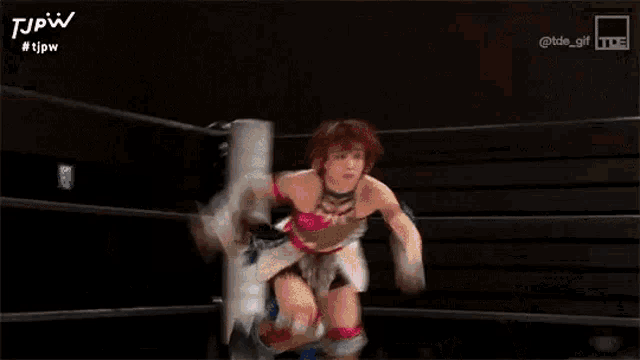a woman is standing in a boxing ring with a blurred background .