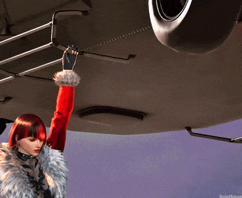 a woman with red hair and a fur coat is standing in front of a car with a solidsmax logo in the corner