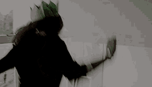 a woman is wearing a green mask and a black jacket .