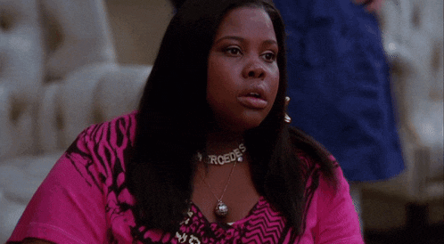 a woman wearing a pink shirt and a necklace that says mercedes