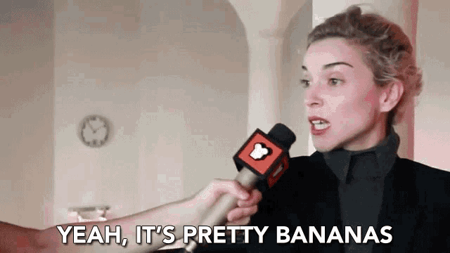 a woman talking into a microphone with the words yeah it 's pretty bananas behind her
