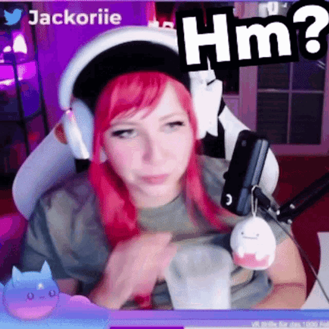 a girl with red hair is sitting in front of a microphone and a sign that says hm .