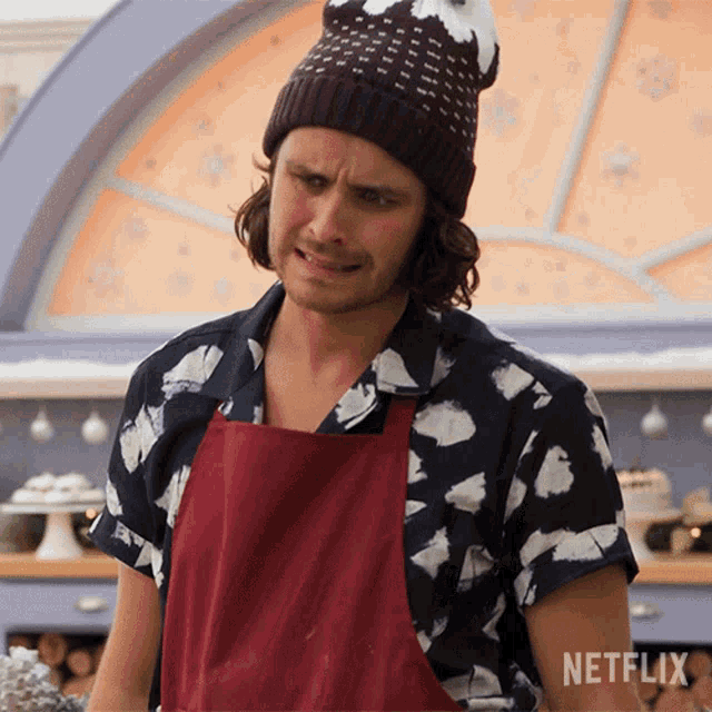 a man wearing a beanie and an apron is standing in front of a netflix logo