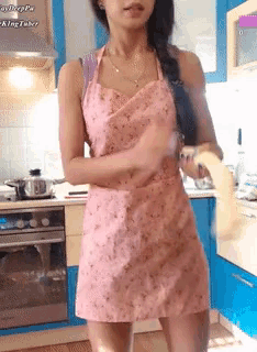 a woman in a pink apron in a kitchen