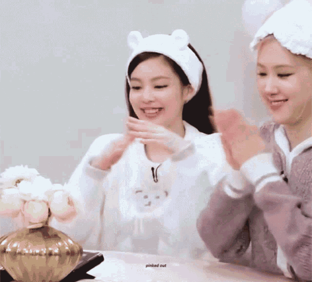 a woman wearing a headband with ears is sitting next to another woman wearing a headband with ears .
