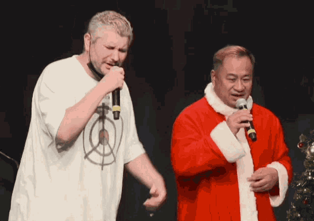 a man in a santa suit sings into a microphone