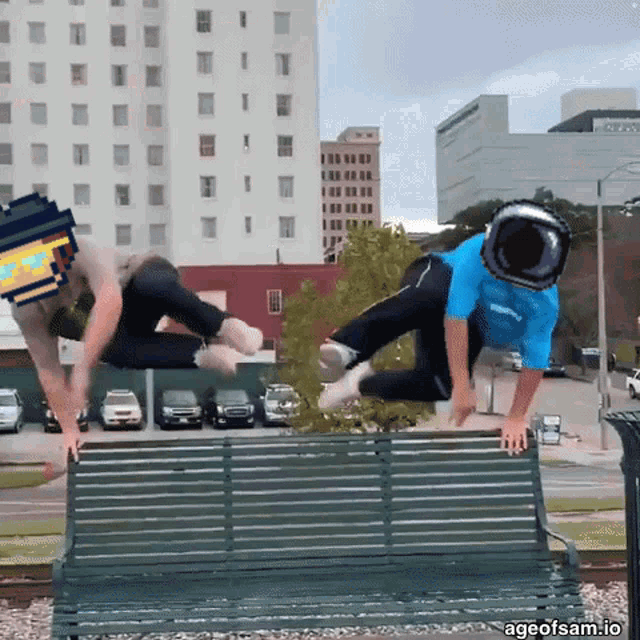 two men are jumping over a park bench with ageofsam.io written in the corner