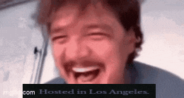 a man with a mustache is laughing with his mouth open and the words `` hosted in los angeles '' behind him .