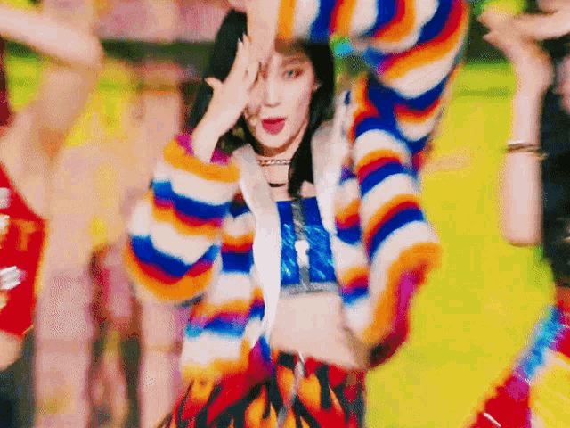 a woman in a colorful sweater is dancing on a yellow background