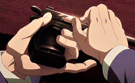 a man in a suit is holding a black gun