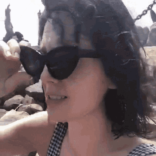 a woman wearing sunglasses and a black and white checkered shirt