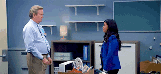 a man and a woman standing next to each other in a room