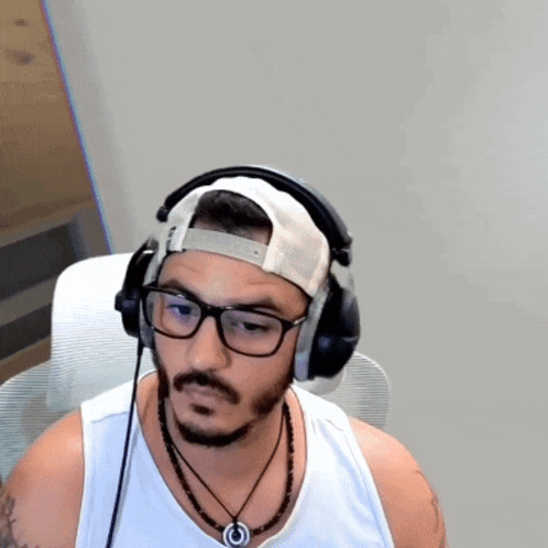 a man wearing headphones and a hat with the letter o on it