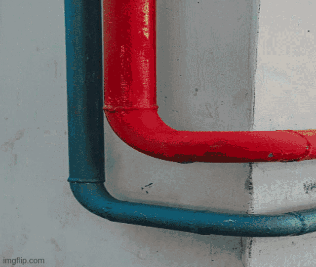 a red pipe and a blue pipe are connected to each other on a wall