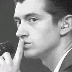 a black and white photo of a man with his finger on his lips