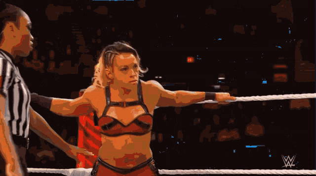 a woman in a wrestling ring with a w logo on the bottom