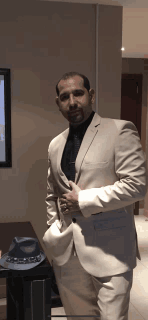 a man in a suit and tie stands in front of a table