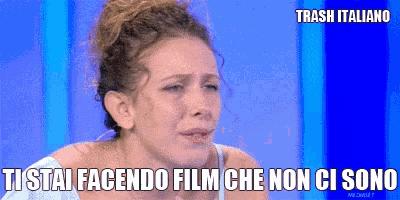 a woman is crying in front of a blue background that says trash italiano on it