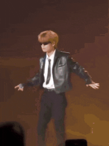 a blurry picture of a man in a suit holding a microphone