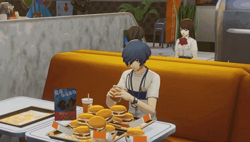 a man sits at a table eating a hamburger