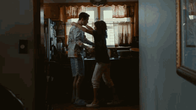 a man and a woman dancing in a kitchen